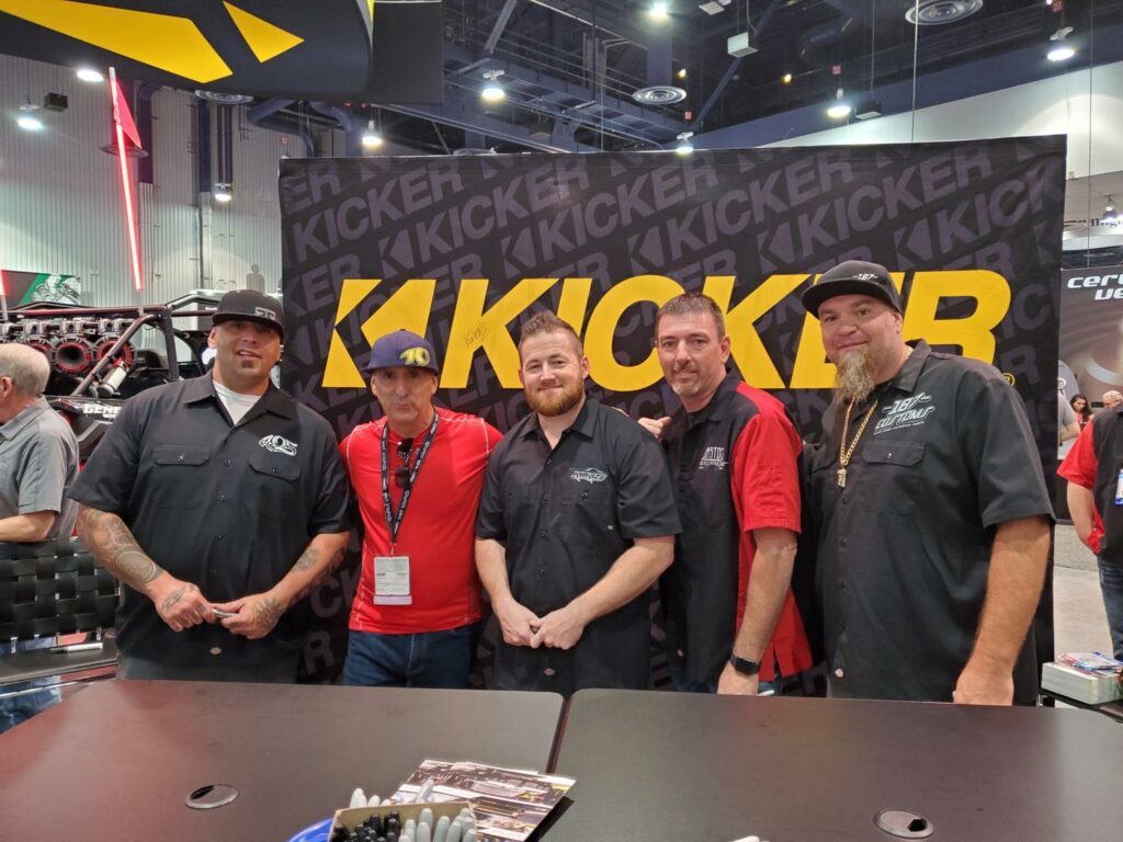 Five Person Standing Infront of Kicker Logo