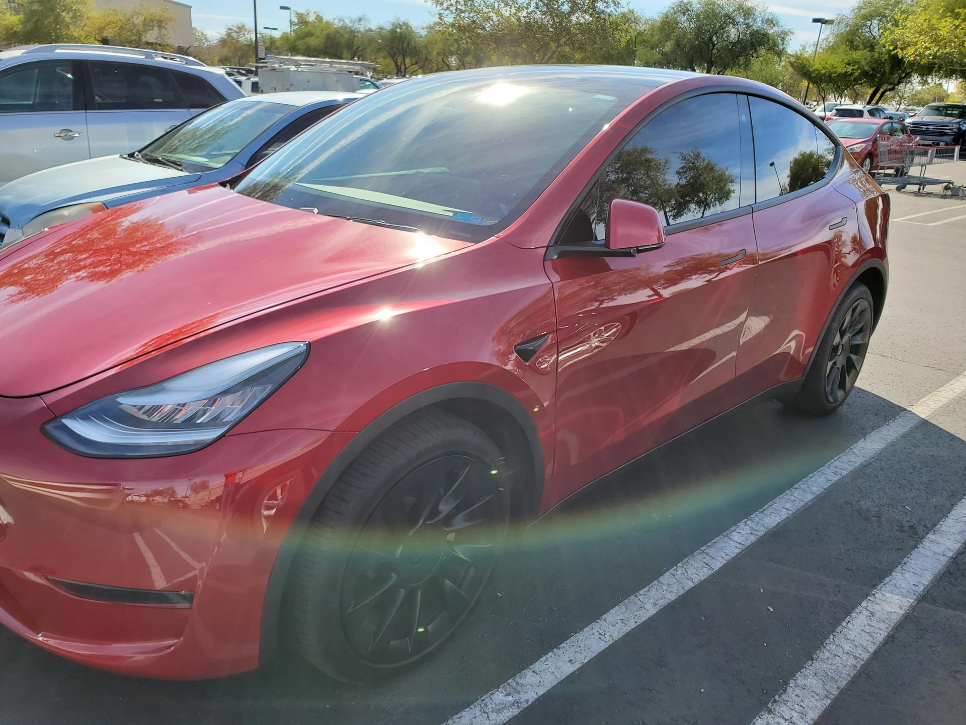 A Parked Red Tesla Model 3 in a Parking Lot
